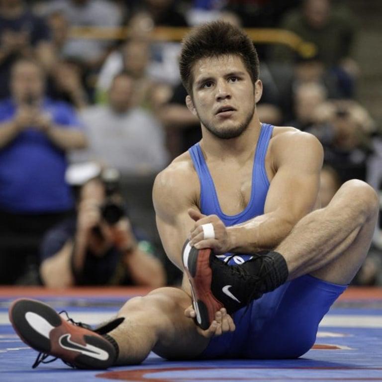 Henry Cejudo removing his wrestling shoes, signalling retirement
