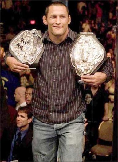 Dan Henderson was the real first Champ Champ in MMA history. He simultaneously held the PRIDE Middleweight and Welterweight titles (185 and 205).