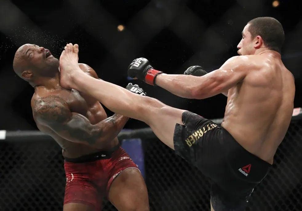 Robert Whittaker rocks Yoel Romero with a head kick. Credit: Jim Young - AP Photo.