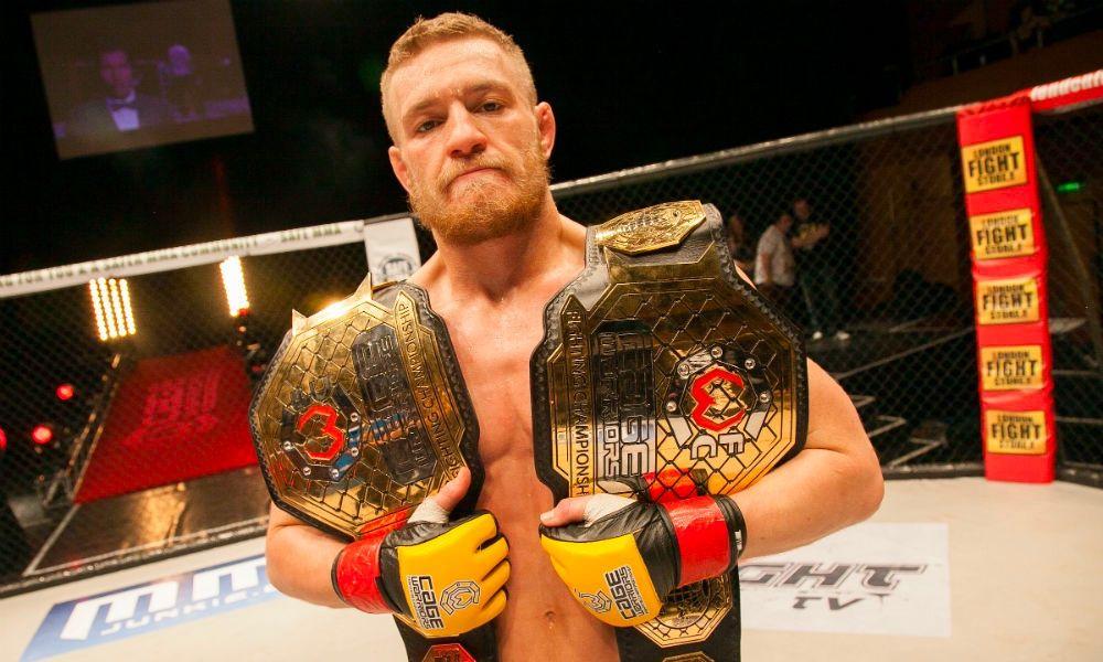 Conor McGregor wearing both the Featherweight and Lightweight Cage Warriors Championships. Credits to: Dolly Clew-Cage Warriors.