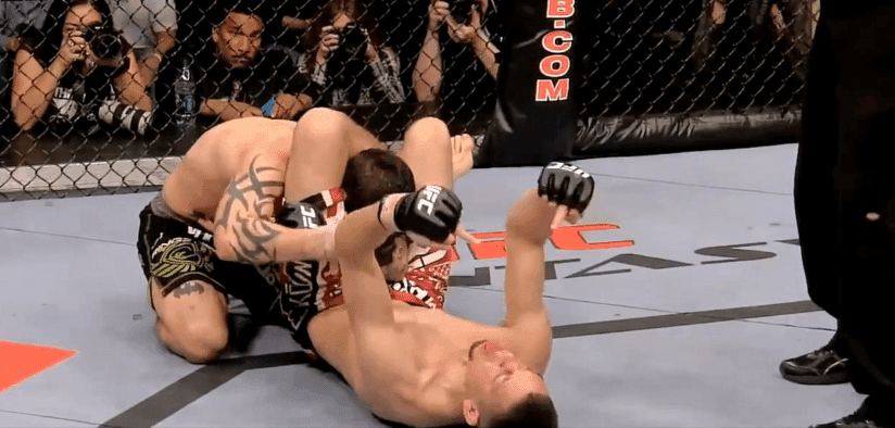Nate Diaz secures Kurt Pellegrino in a triangle choke then puts up his middle fingers. Credits to: Zuffa LLC