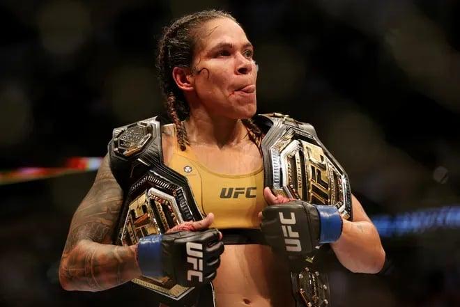 Amanda Nunes flaunts her two belts. Credit: Carmen Mandato - Getty Images.