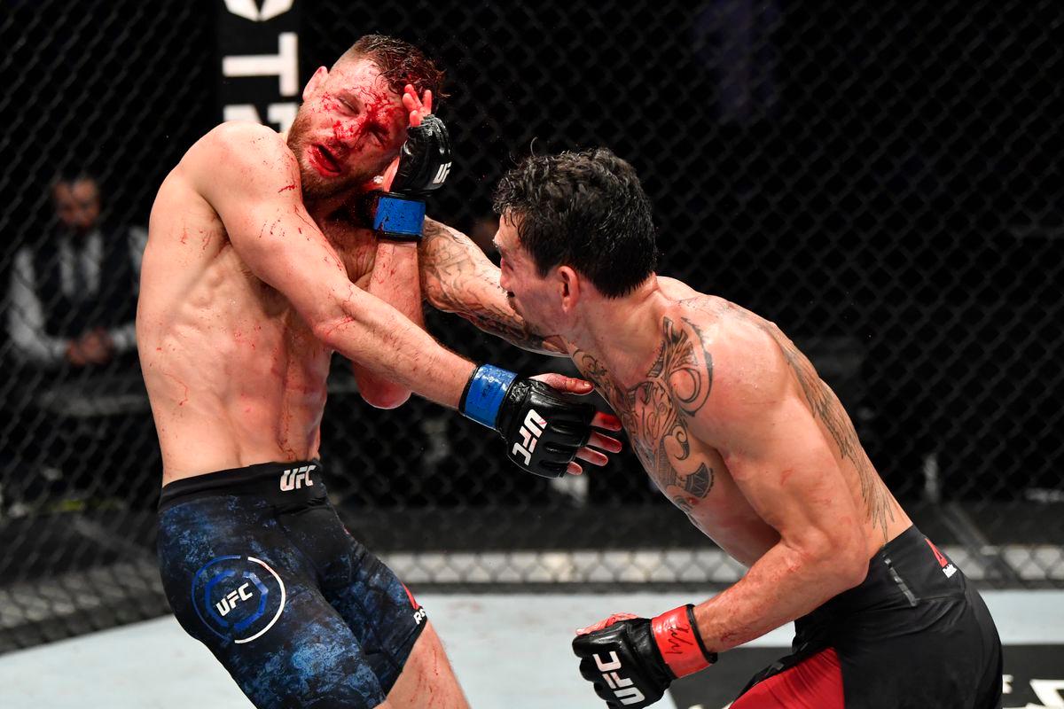 Max Holloway throws a right hand at a battered Calvin Kattar. Credit: MMA Mania.