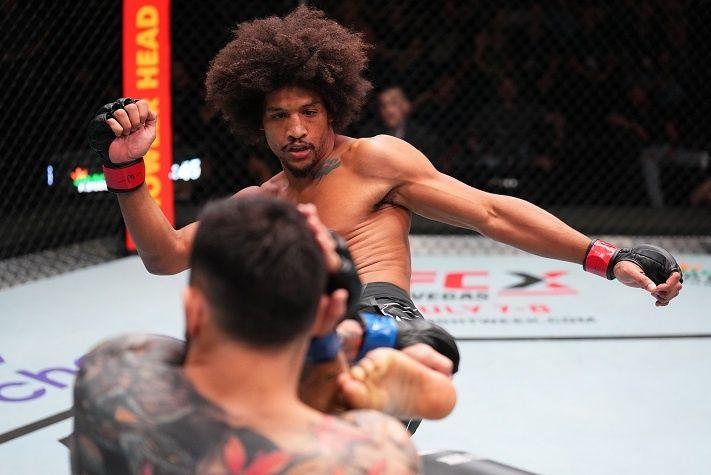 Alex Caceres kicking Daniel Pineda in their Fight Of The Night attraction, Credits to: Chris Unger - Zuffa LLC.