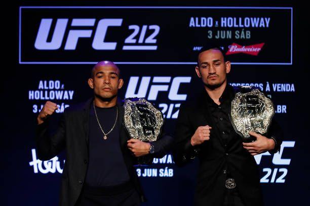 José Aldo and Max Holloway taking photos with their respective titles. Credits to: Buda Mendes - Zuffa LLC.