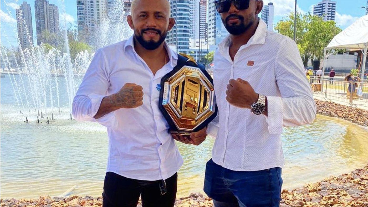 Deiveson Figueiredo (left) posing with his belt, next to his brother Francisco (right). Photo by MMAFighting.