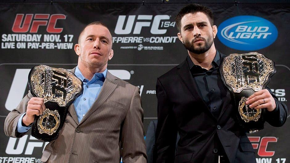 GSP and Carlos Condit pose with their belts. (Graham Hughes - Canadian Press)