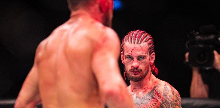 Sean O'Malley stares down Petr Yan during his split-decision win. Credits to: MMA Weekly