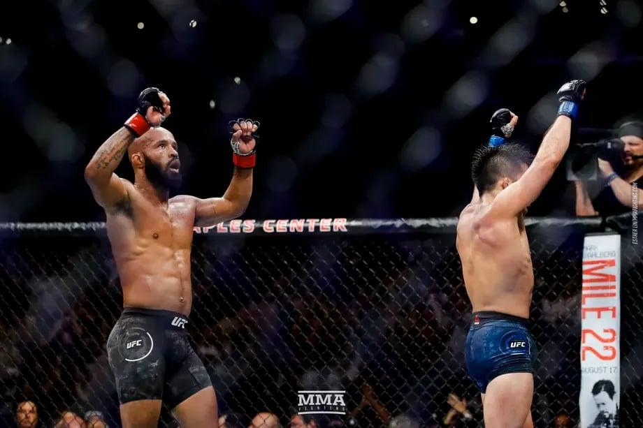 Demetrious Johnson and Henry Cejudo raise their hands after UFC 227. Credits to: Esther Lin - MMA Fighting.